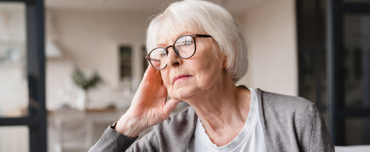 elderly woman sitting down, looking stressed