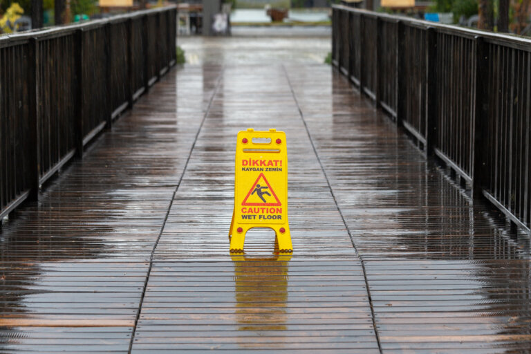 slip and fall sign on wet bridge