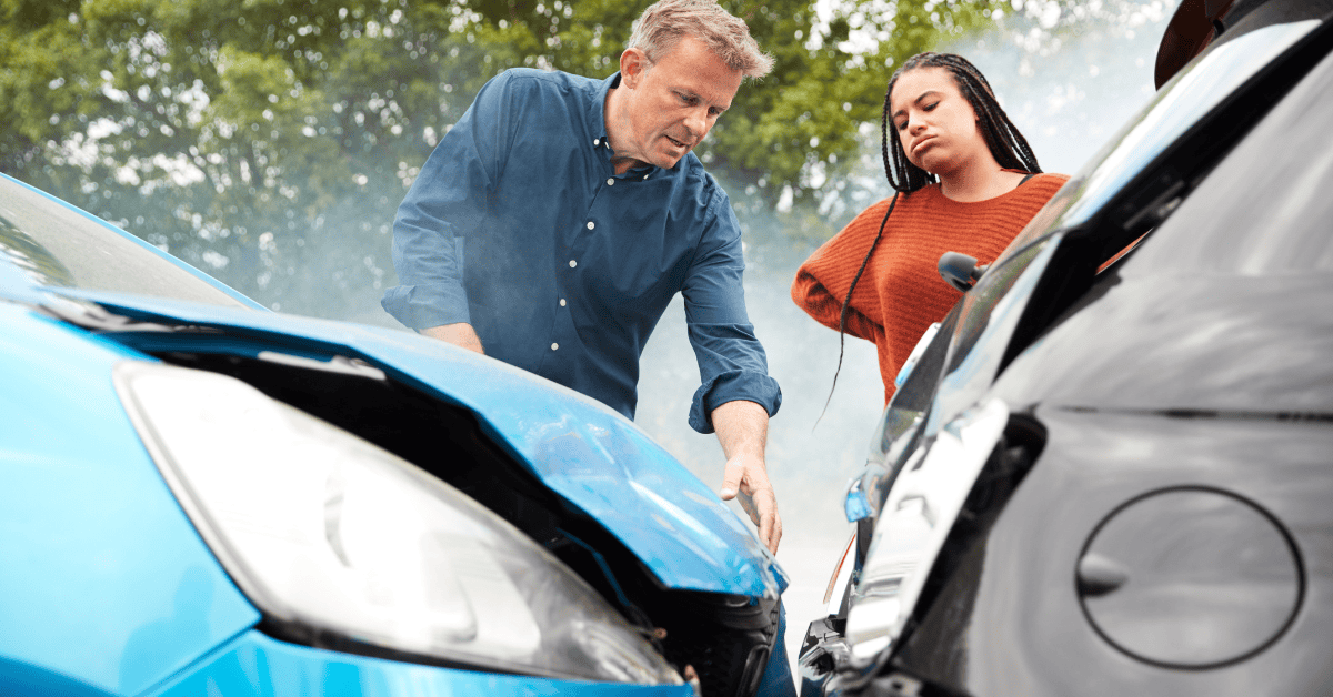 Drivers inspecting damage after a low impact car accident in Arkansas, showing concern despite minor vehicle damage.