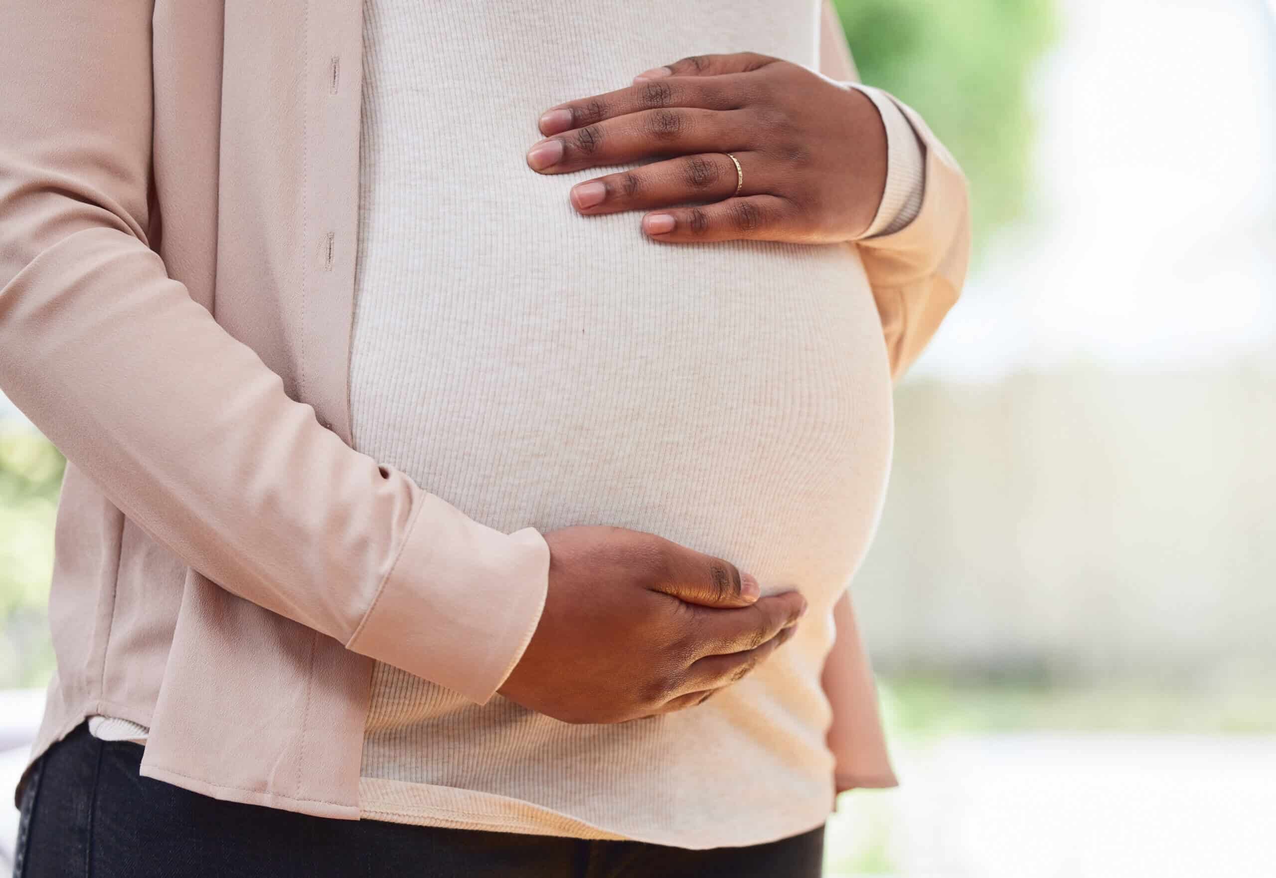 Pregnant woman holding her belly.